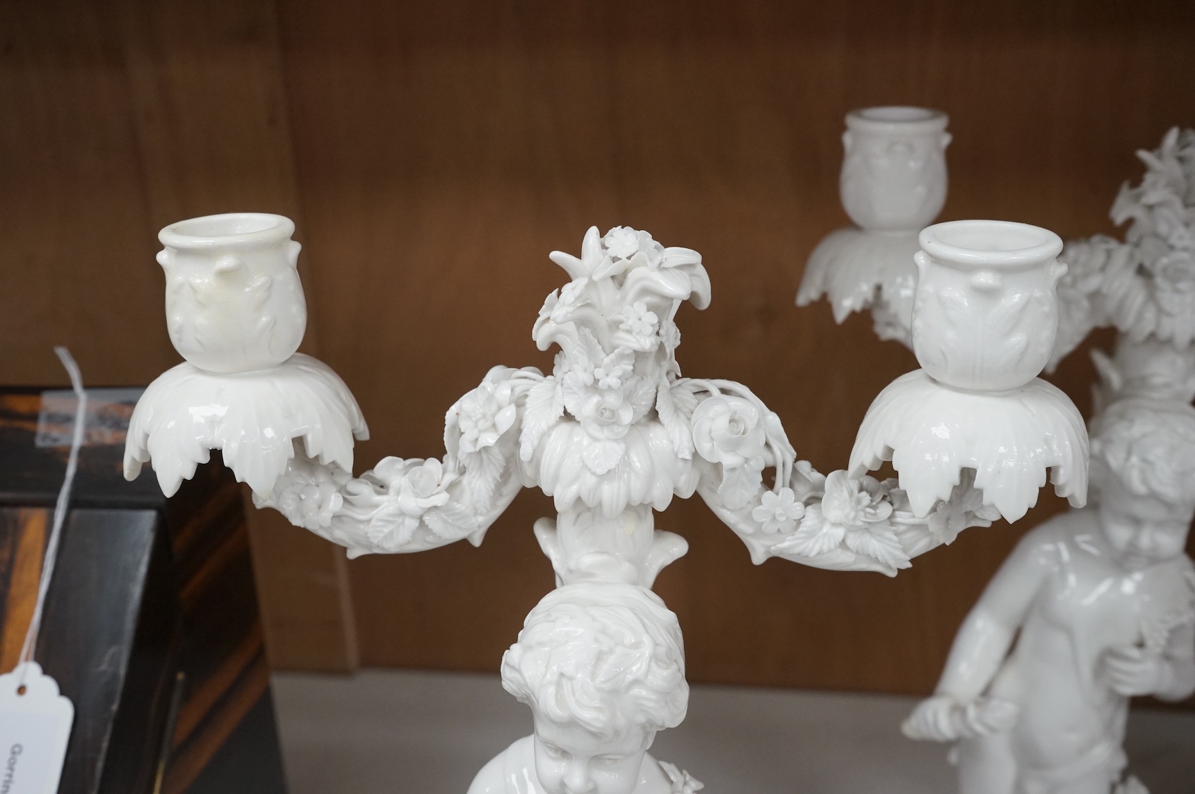 A pair of figural two branch candelabra, crossed swords marks, 36cm high
